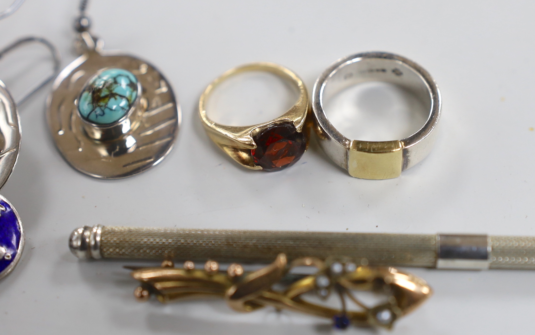 Mixed jewellery including a pair of silver and turquoise earrings by Pruden & Smith, two other silver rings, a 9ct and garnet set ring, a silver twizzle stick, a 9ct and gem set brooch and a pair of white metal and ename
